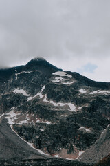 Rocky mountain with scattered white layers against a foggy
