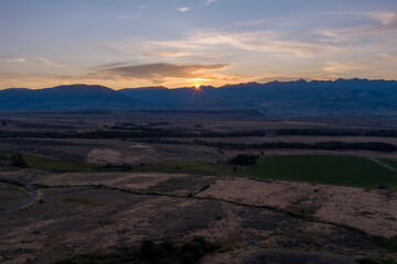Aerial view of the sun setting behind the Gallatin Mountains near Pray (Paradise Valley) Montana.