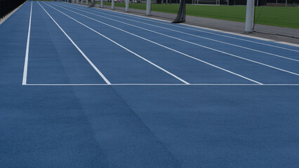 陸上競技場の風景。青色のレーン。100メートル。