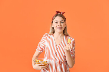 Beautiful young woman with tasty nachos on color background