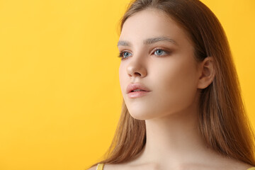 Naklejka premium Beautiful young woman with dyed eyebrows on color background