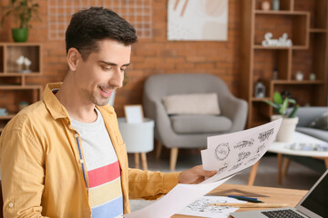 Young male calligrapher with sketches at home