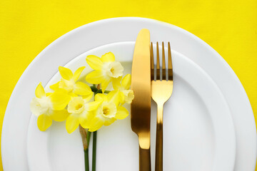Beautiful table setting with narcissus flowers, closeup