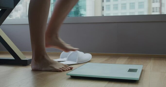 Woman stands on scale to measure her weight