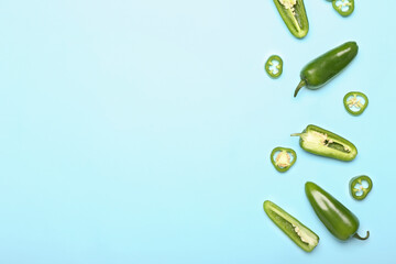 Cut green jalapeno peppers on color background