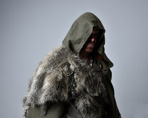 Close up  portrait of  young handsome man  wearing  medieval Celtic adventurer costume with hooded...