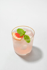 Glass of tasty grapefruit margarita on white background