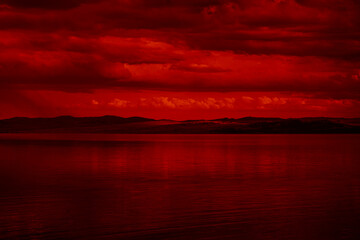 The surface and the island of red water scenery. Sky with clouds. Bloody sunset background with...