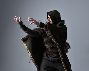 Close up  portrait of  young handsome man  wearing  medieval Celtic adventurer costume with hooded...