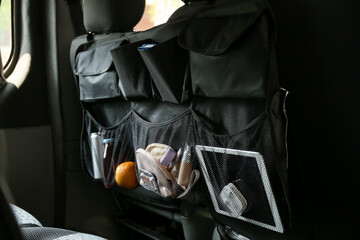 Travel organizer with different things on car seat, closeup - obrazy, fototapety, plakaty