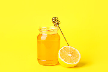 Jar of honey with lemon on color background