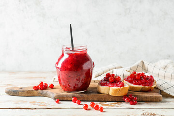 Composition with red currant jam and sandwiches on wooden table