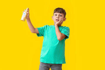 Little boy with mosquito repellent on color background