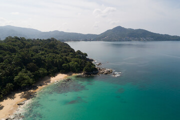 Obraz premium High angle view Tropical sea with wave crashing on seashore and high mountain located in Phuket Thailand aerial view drone top down Amazing nature view landscape Beautiful sea surface.