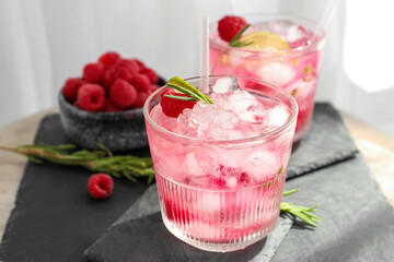 Glasses of tasty raspberry lemonade on table