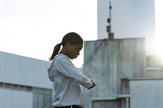 スマートウォッチを見るスポーツウェア姿のアフリカ系外国人女性