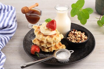 Fresh Baked Delicious Homemade Croissant Waffle or Croffle with Maple Syrup, Chopped Almond, Sugar Dusting, and Strawberry. Easy Making for Breakfast