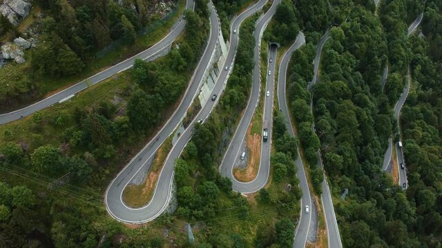 Aerial drone above the scenic mountain serpentine road Paluzza Pl&ouml;ckenpass in Italy by the natural Austrian alps in summer with green forest trees in nature and travel vacation cars on the street
