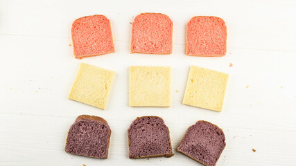 Top View Pink, White, and Purple bread for Sandwich Breakfast. Isolated on White Wooden Background. Concept for Clean Bakery