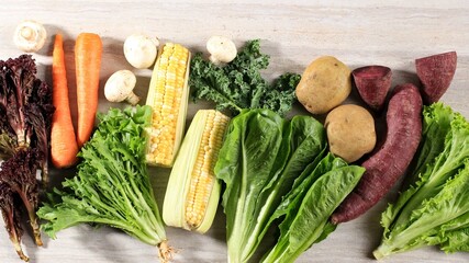 Healthy Food, Various fresh  Vegetables Leaf On a Brown Marble Wooden Background. Top View. Copy Space. Kale, Lettuce, Purple Lettuce, Endive, Carrot, Mushroom, Corn, Puplre Sweet Potato, Potato