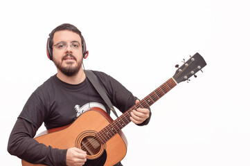 happy white adult Hispanic Latino white man with beard headphones and glasses posing playing his guitar on a white background