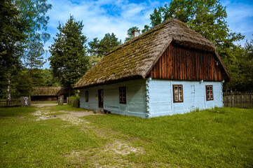 Fototapeta na wymiar Stara polska wieś. Chaty pokryte strzechą. Wiejskie klimaty.