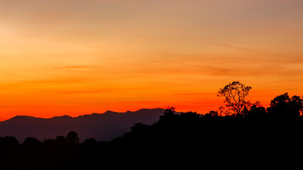 Fototapeta na wymiar sunrise or sunset with mist and mountain. Orange sky.