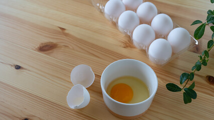 Fototapeta na wymiar テーブルの上の生卵。割れた卵の殻。