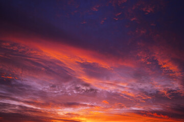 Purple red orange sunset. Colorful sky with clouds background for design.