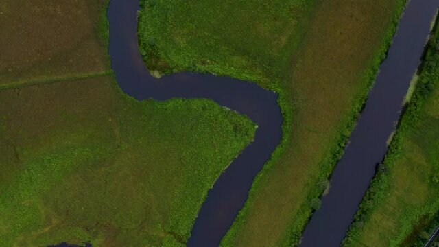 Failmore River, Maum, Connemara, County Galway, Ireland, July 2021. Drone Bird's eye view, slowly following the course of the river west, passing over Oxbow Lake and grassy marshland.