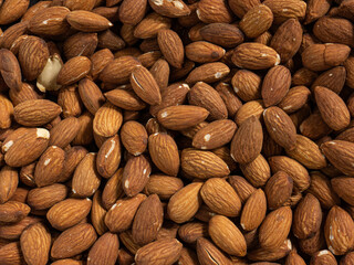 almond in black plate on wood table for food and health  concept