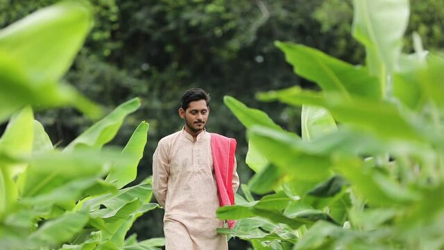 Young Indian farmer at green banana field