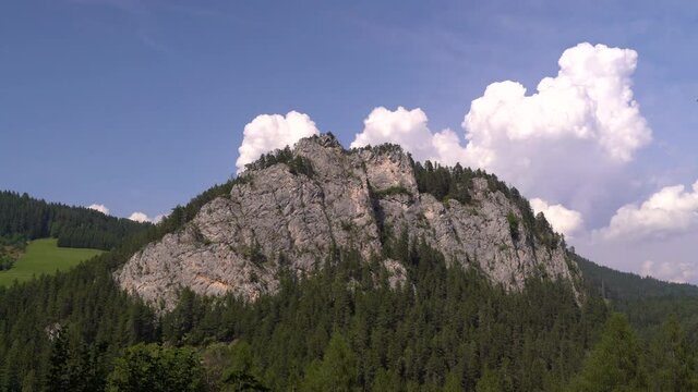 High rocky mountain in nature with beautiful cloud formation and forest