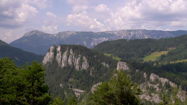 Stunning landscape time lapse with mountains, greenery and fast moving clouds - panning shot