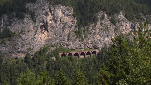 Beautiful train tunnel at Semmering Railway in rocky cliffs with passing shadows