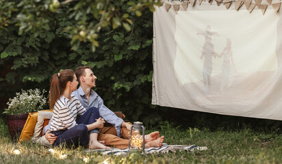 Family couple watching film in garden