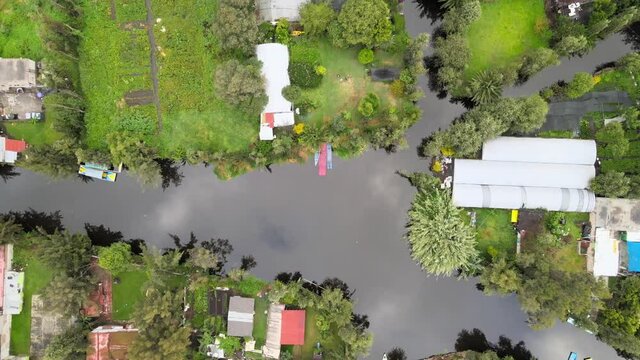 Jib down above a canal of Xochimilco, Mexico City. Reflects of clouds can be see in water