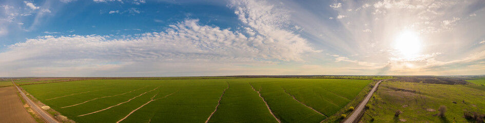 panoramic shot of soil erosion caused by water, aerial view of a green field at day time
