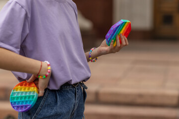 a teenage girl plays with pop it. A new modern anti-stress toy in the hands of a teenager. The concept of mental health. The toy is designed to combat stress and anxiety. Modern fashionable toy