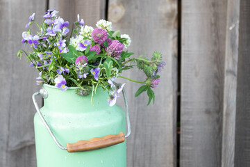 A bouquet of wild flowers in a green metal can