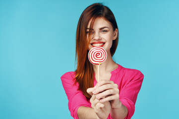 woman in pink shirt with lollipop in hands charm blue background