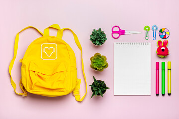 Back to school, education concept. Yellow backpack with school supplies - notebook, pens, ruler, calculator, scissors isolated on pink background Top view Copy space Flat lay composition Banner