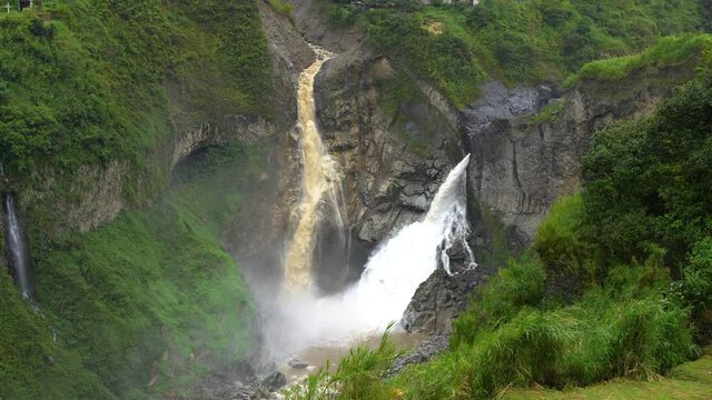 Huge waterfall crashing down the green amazon rainforest in Ecuador,slow motion aerial top down