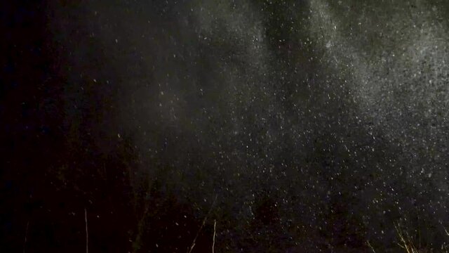 A night time heavy winter storm blows in and snow swirls and drifts around under the house light in this smooth steady clip
