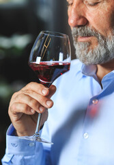 A senior sommelier is tasting red wine.