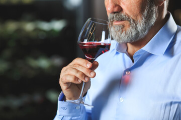 A senior sommelier is tasting red wine.