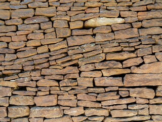 The fence is made of different stones.