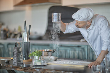 french chef in the kitchen preparing food, cooking, haute cuisine, man with mustache