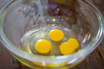 Yellow egg yolks in a clear transparent bowl.