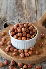 Organic hazelnut. Hazelnut on wood background. Bulk hazelnut kernels. Hazelnut on a ceramic plate